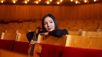Ami-Louise Johnsson sitter på parkett i Berwaldhallen och håller i sin viola .