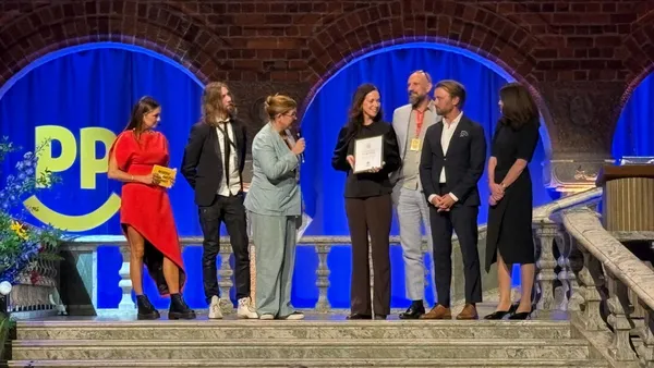 Sveriges Radio tar emot Happiness Impact Award 2026, Vid en ceremoni i Blå Hallen igår fanns Sveriges Radio-representanter på plats för att ta emot priset av professor Michael Dalén. Elin Claesson (med mikrofonen), Sara Möndell, Mårten Randberg, Anders No