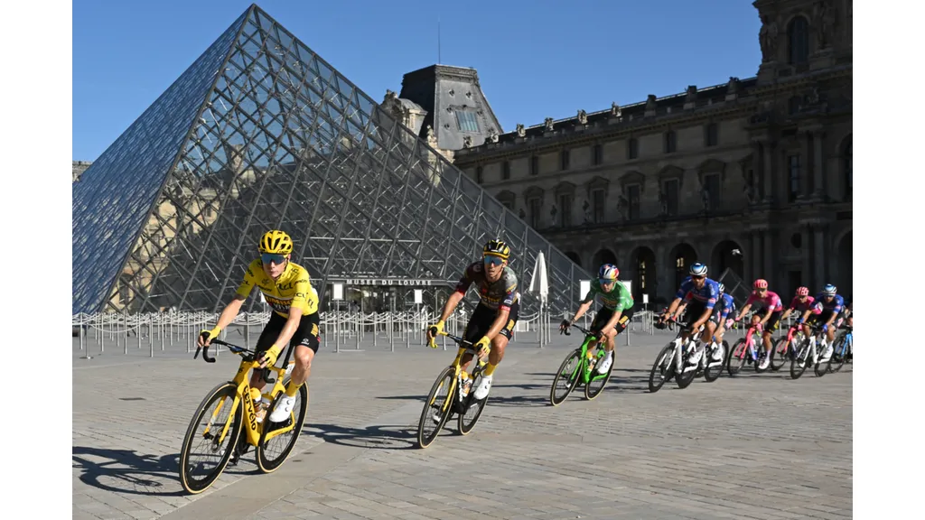 Jonas Vingegaard (L) wearing the overall leader's yellow jersey cycles past the Louvre Pyramid at the Tour de France 2023 (Getty Images).jpg