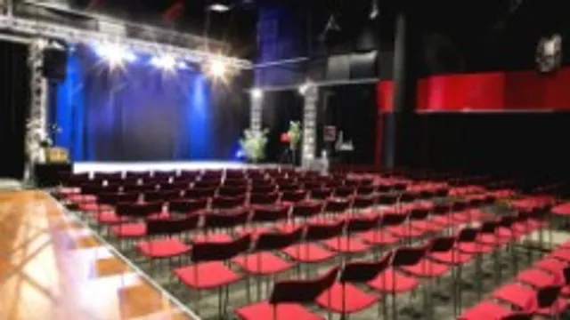 Studio 4 röda säten, strålkastare över en scen.
