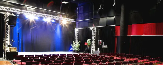 Studio 4 röda säten, strålkastare över en scen.
